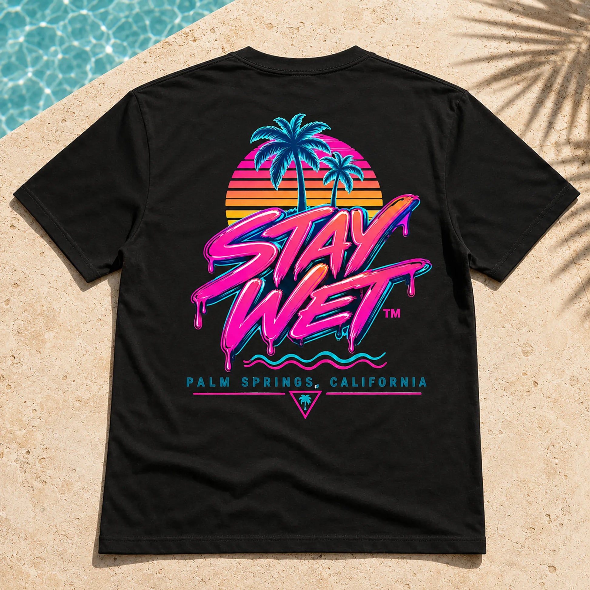 Close-up of the black Stay Wet Palms tee showing the large neon palm tree and sunset back graphic