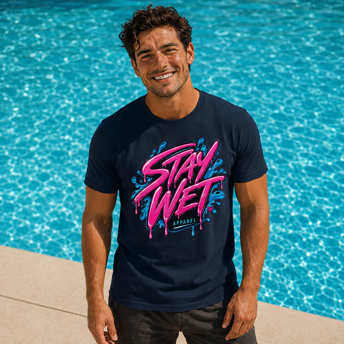 Woman wearing the white Stay Wet Signature Tee with a large front logo beside a bright blue swimming pool.